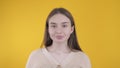 Girl takes off a medical mask on a yellow background