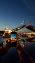 Girl takes photo on phone breeding Palace Bridge in St. Petersburg during White Nights. View from Neva River to raised bridge.