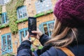 Girl takes a picture with the mobile phone in the street of a picturesque town Royalty Free Stock Photo