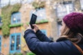 Girl takes a picture with the mobile phone in the street of a picturesque town Royalty Free Stock Photo