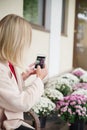 The girl takes pictures of flowers. Outdoor. Royalty Free Stock Photo