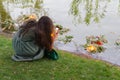 Girl takes pictures of a wreath of flowers in the lake, performing the traditional rite of the holiday of Ivan Kupala