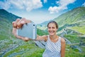 The girl takes a selfie photo of Transfagarasan mountain road. Romania. Royalty Free Stock Photo