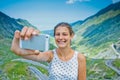 The girl takes a selfie photo of Transfagarasan mountain road. Romania. Royalty Free Stock Photo