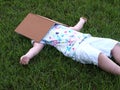 little girl lying in grass taking break under book Royalty Free Stock Photo