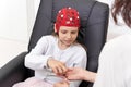 Girl taking electrodes from a doctor in a biofeedback therapy