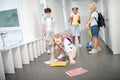 Girl taking her notebooks from floor after children pushed her Royalty Free Stock Photo