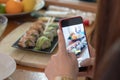Girl taking a photo of a home made sushi plate with two different sushi rolls Royalty Free Stock Photo