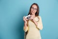 Girl taking photo using photocamera over blue background Royalty Free Stock Photo