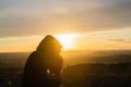 Girl taking photos during colored sunset in quarry Hady Brno with view inside city