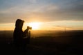 Girl taking photos during colored sunset in quarry Hady Brno with view inside city