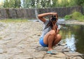 Girl taking photos in front of dam of pond