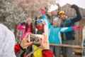 Girl taking pictures of happy friends on cold winter day Royalty Free Stock Photo