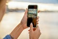 Girl taking pictures of a landscape, close-up of a phone in her Royalty Free Stock Photo