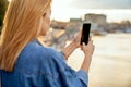 Girl taking pictures of a landscape, close-up of a phone in her Royalty Free Stock Photo