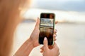 Girl taking pictures of a landscape, close-up of a phone in her Royalty Free Stock Photo