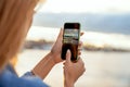 Girl taking pictures of a landscape, close-up of a phone in her Royalty Free Stock Photo