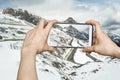 Girl taking pictures on mobile smart phone in snow mountain Royalty Free Stock Photo