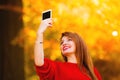 Girl taking self picture selfie with smartphone camera outdoors Royalty Free Stock Photo