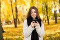 girl taking selfie on phone with coffee on yellow sunny park Royalty Free Stock Photo