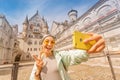 girl taking selfie photo in Neuschwanstein castle inner courtyard. Travel destinations in Germany and Europe concept Royalty Free Stock Photo