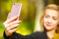 Girl taking a selfie on smart phone in autumn park Royalty Free Stock Photo