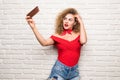 Girl taking selfie smart phone camera excited happy smile woman over white brick office wall Royalty Free Stock Photo