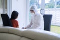 Girl talking with medical worker in hazmat suit