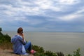 Girl talking on the phone on the beach and looking at the sea Royalty Free Stock Photo