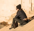 Girl talking on the phone and sitting on stairs - warm filter - back view