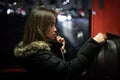 A girl is talking on a public telephone at night on the street. Royalty Free Stock Photo