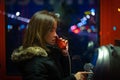 A girl is talking on a public telephone at night on the street. Royalty Free Stock Photo