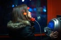 A girl is talking on a public telephone at night on the street. Royalty Free Stock Photo