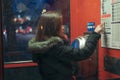 A girl is talking on a public telephone at night on the street. Royalty Free Stock Photo