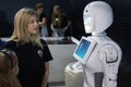 A girl talking to a robot android in a dark room.