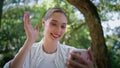 Girl talking video chat holding smartphone in forest closeup. Woman calling park Royalty Free Stock Photo