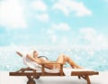 Girl tans at the beach with a deckchair Royalty Free Stock Photo