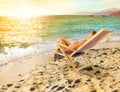 Girl tans on a deck chair on a beautiful beach Royalty Free Stock Photo