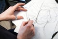 Girl tattoo artist draws a sketch. Close-up of hands Royalty Free Stock Photo