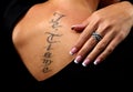 Girl with a tattoo on the back of which is a hand with a with luxury ring