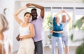 Girl teacher dances pair dance with african male student of fitness class Royalty Free Stock Photo