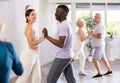 Girl teacher dances pair dance with african male student of fitness class Royalty Free Stock Photo