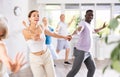 Girl teacher dances pair dance with african male student of fitness class Royalty Free Stock Photo