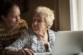 A girl teaches her grandmother how to use the computer. Royalty Free Stock Photo