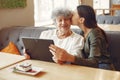 Girl teaching her grandmother how to use a tablet Royalty Free Stock Photo