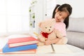 Girl teaching teddy bear doing school homework