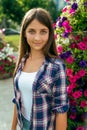 Girl teenager beautiful 11-14 years on the background of a flower bed. Happy smiles. In the summer in city after school Royalty Free Stock Photo