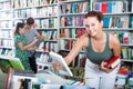 Girl teenager choosing book in shop