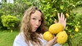 girl teenager have fun dancing smiles and laughs against the backdrop of a lemon tree in her hands she has lemons she