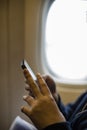 Girl teenager`s hands using a smartphone on the airplane. Royalty Free Stock Photo